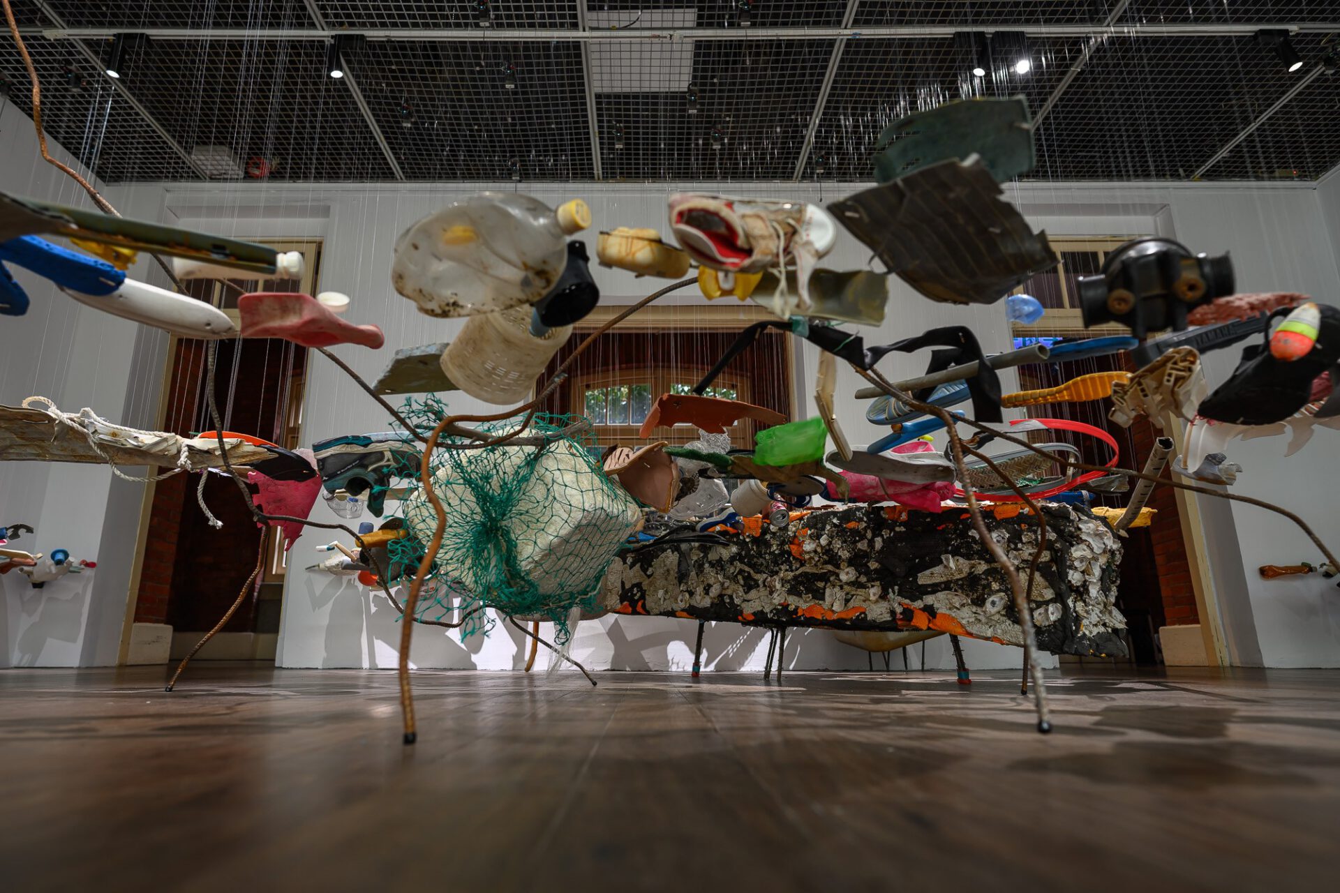 Low view beneath the layered suspended objects and connecting wires.
