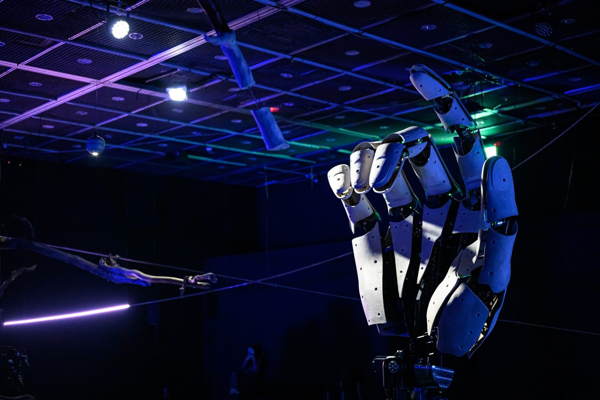 Close view of the mechanical hand under blue and violet gallery lighting.